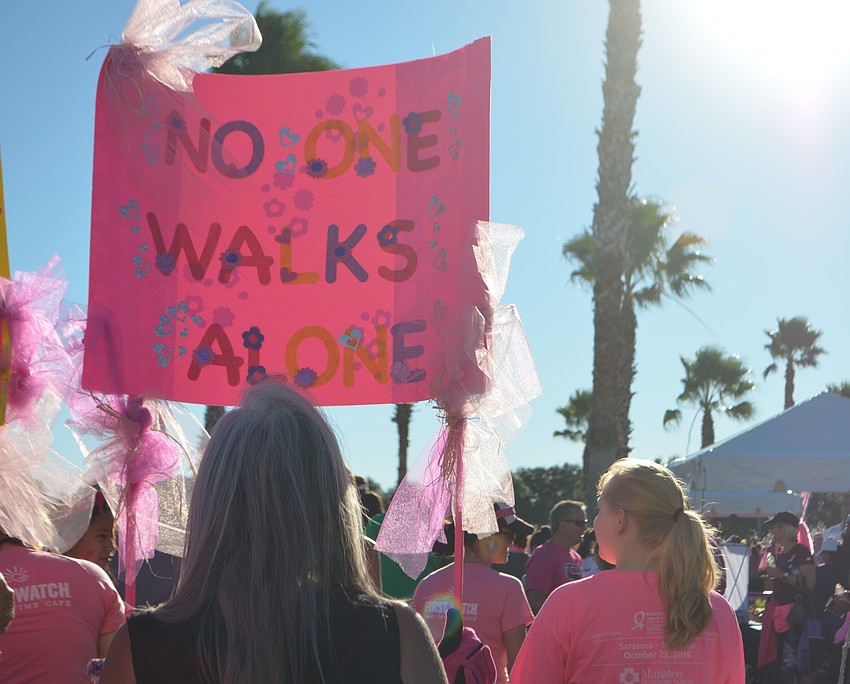 Sarasota's Faustina Fayo-Abrams, 65, holds her sign during the Strides Against Breast Cancer Walk at the Sarasota Polo Club.
