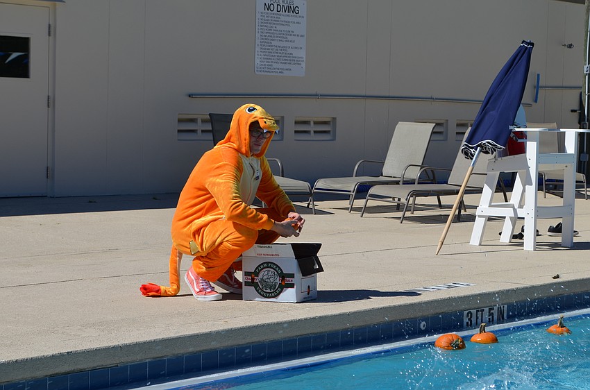 Nathan Tharp adds miniature pumpkins to the pool.