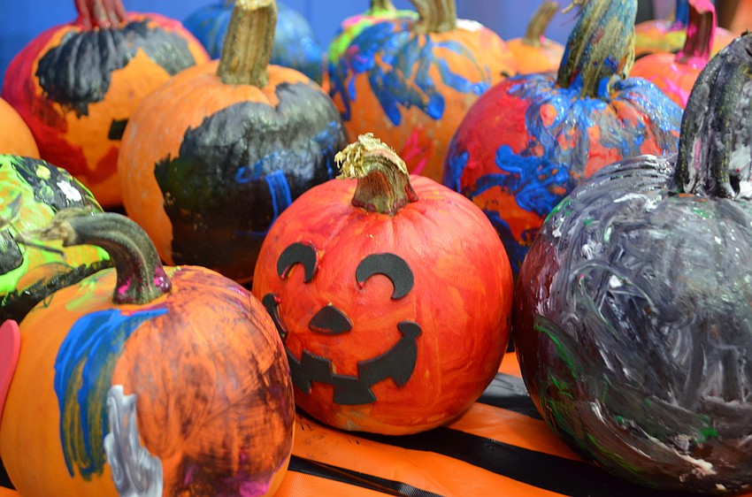 Painted pumpkins are set aside to dry.