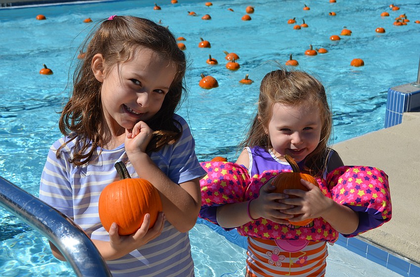Sisters Victoria and Hailey Singer are proud of the pumpkins they swam to retrieve.