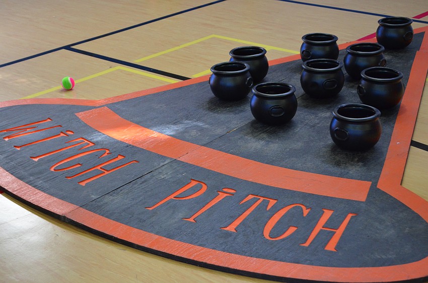 A game of Witch Pitch is set up for children to toss bean bags into cauldrons.