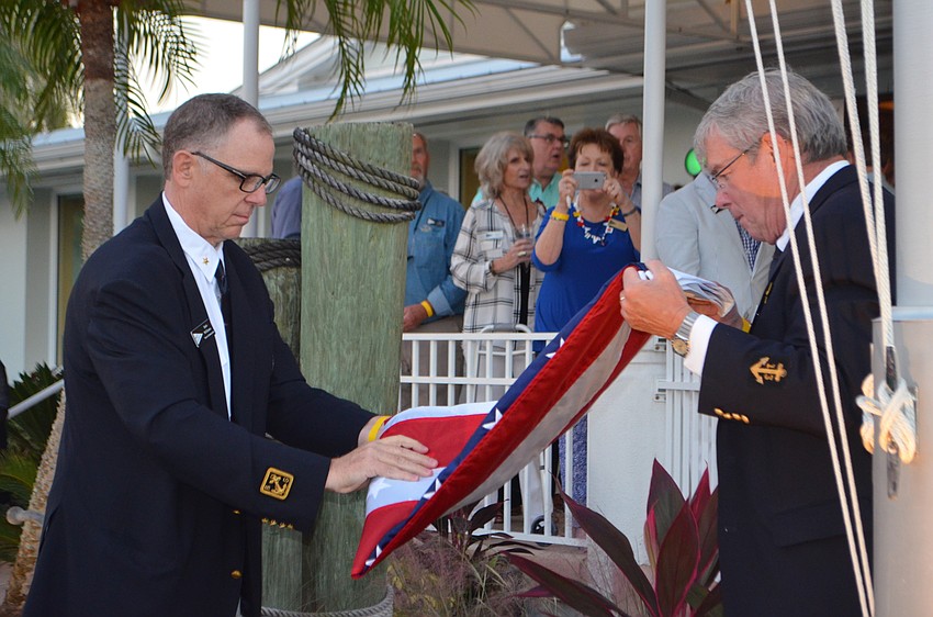Rear Commodore Bob Williams and Vice Commodore fold the flag during Bird Key Yacht Club’s MarinaFest.