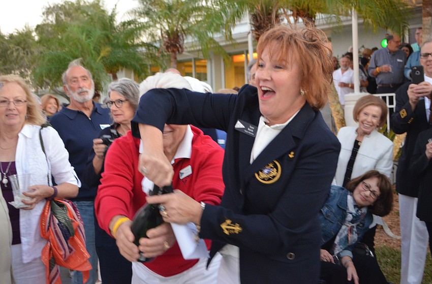 Tami Walsh pops open a bottle of champagne to christen the new docks at Bird Key Yacht Club’s MarinaFest on Oct. 22.