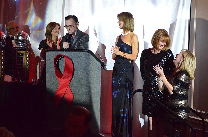 Producer Stephen Sieg surprises Co-Chairwomen Jackie Rogers, Penny Hill, Emily Walsh and Susan Malloy Jones by inviting all past CAN competitors to join him on the dancefloor.