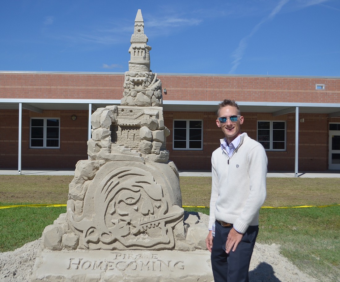 Commercial Art and Business Teacher at Braden River High School Casey Fabianski, 27, stands with his masterpiece â€” a 12 foot tall sandcastle that he sculpted in the center courtyard at the High School in light of Homecoming.