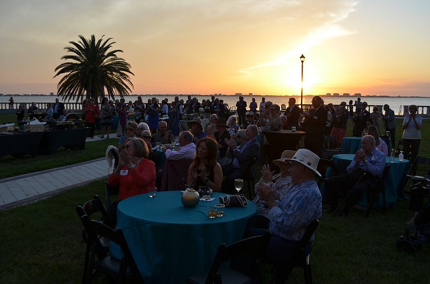 Attendees applaud as the sun sets and the performances come to an end.