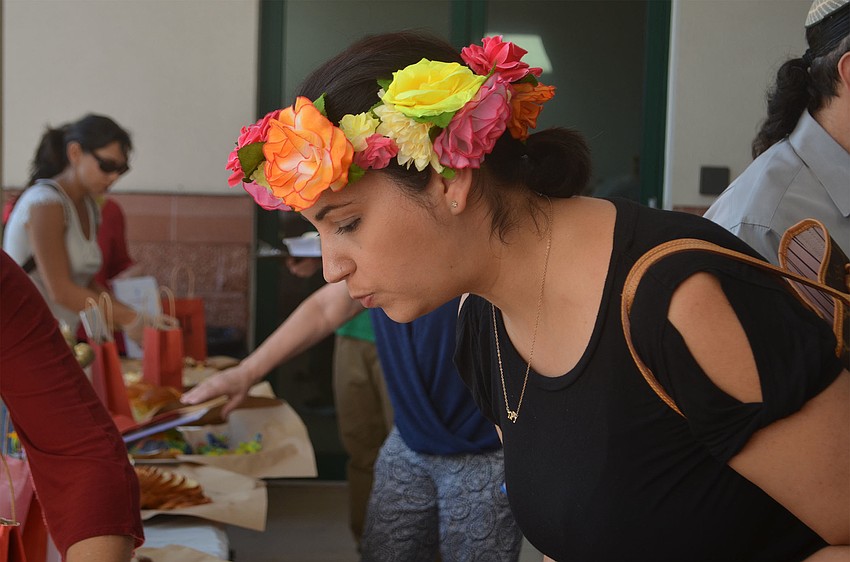 Jessi Sheslow eyes the challah entries before taking a sample. Sheslow works with the Jewish Federation, which submitted two loaves to the competition.