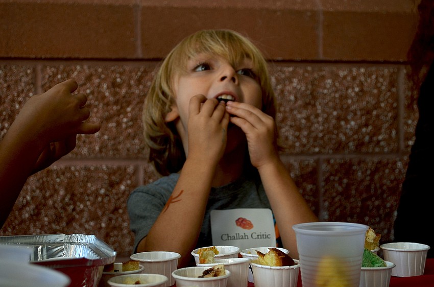 Micah Lifrak stuffs a sample of the chocolate challah bread into his mouth.