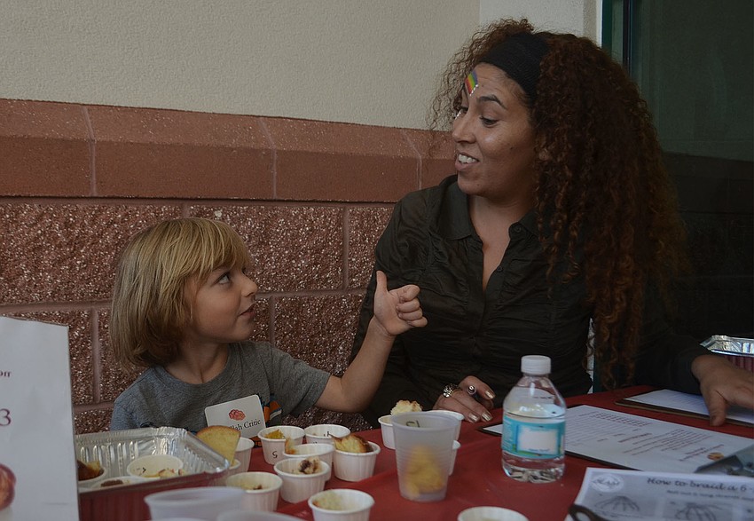 Micha Lifrak gives Hershorin Schiff Community Day School Judaic studies teacher Yael Blecher at thumbs up after trying the chocolate challah.