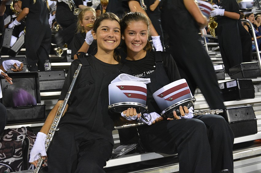Marching band members Allie Behling and Penelope Sugg prepare for an end-of-game performance.