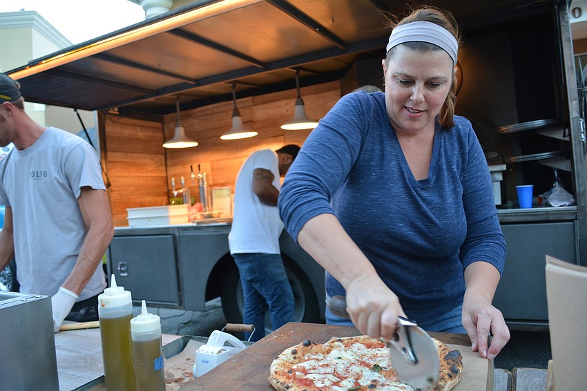 Polpo Pizza Co. owner Danni Bleil, front, boxes up a pizza for a hungry patron.