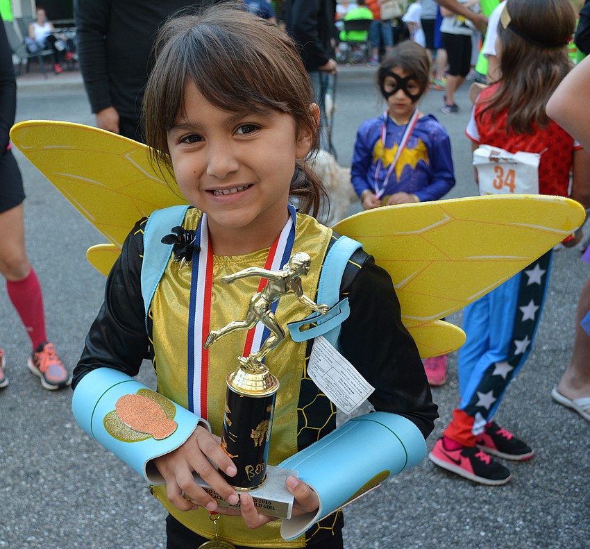 Josephine Linares shows off her trophy for winning the 5-6 girls division.