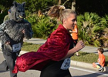 Brittany Parker had an advantage during the Boo Run because she was being chased by a wolf, Ryan Hoppe. The Lakewood Ranch residents were hoping to win the costume contest.