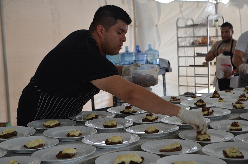 Manuel Delgado finishes preparing the bay leaf braised beef brisket from Looped Square Collective. The dish was one of five courses during the Sip the Sunshine VIP luncheon.