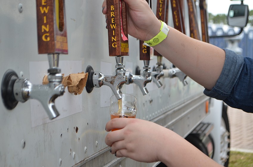 Rachel Wood pours a craft beer sample from Cigar City Brewing during Sip the Sunshine on Oct. 29.