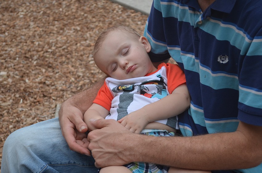 Chase Shepherd, 1, sleeps on his father's lap.