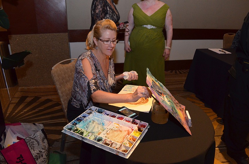 Deborah Yash does a live painting at the event, where she had a mermaid painting available through the auction.