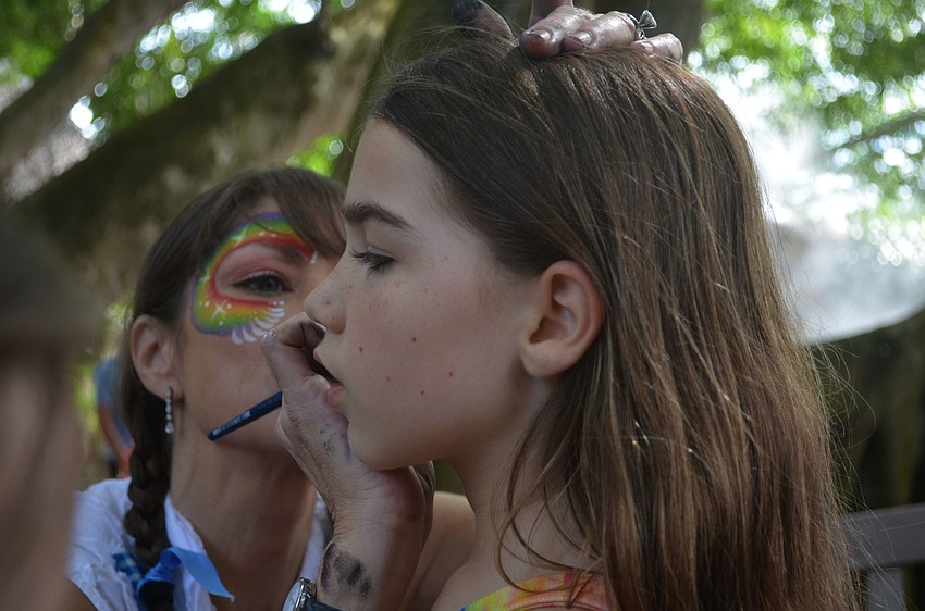 Suzy Kalin paints a sparkly ghost on Brooke Shaal's cheek. Brooke Shaal decided to get a sparkly ghost because she knew her sister, Rowan Shaal, wouldn't like and Brooke didn't want her sister to copy her.