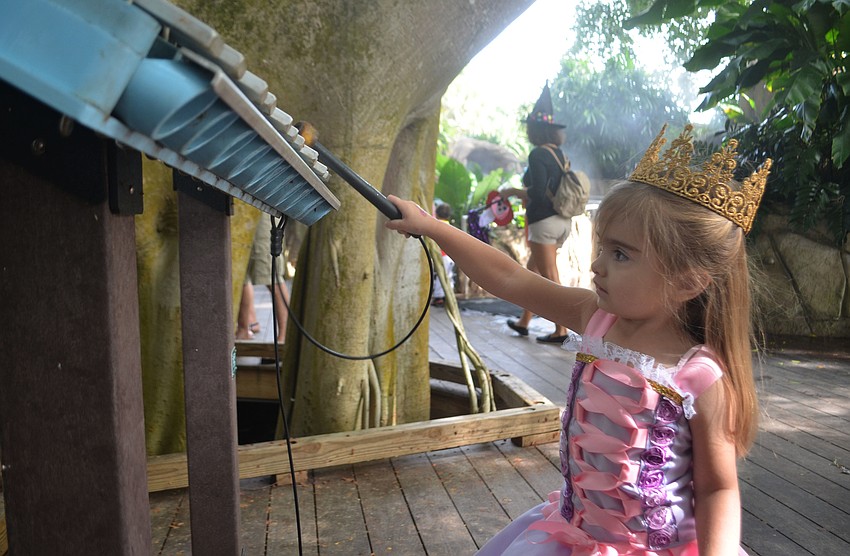 Kimley Hamlin, 3, plays a xylophone  during the Spooktacular event on Sunday at Marie Selby Gardens. Kimley dressed as the Disney princess Rapunzel.