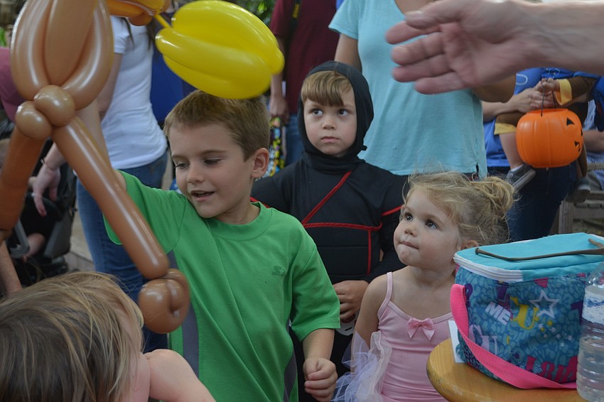 Greyson Miller excitedly grabs his monkey balloon animal.