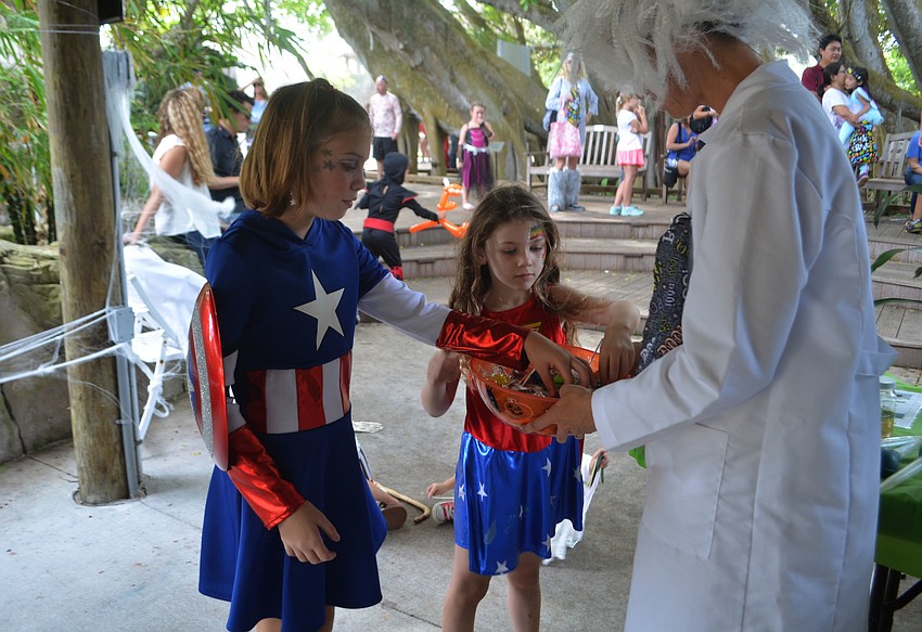 Amayah Hayden and Maxine Gould select candy from Jeannie Perales in the 