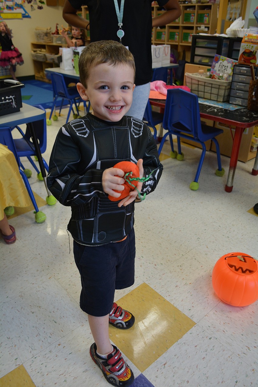Luis Mahiquez, 4, tests his skill at a Halloween-themed bean bag toss.