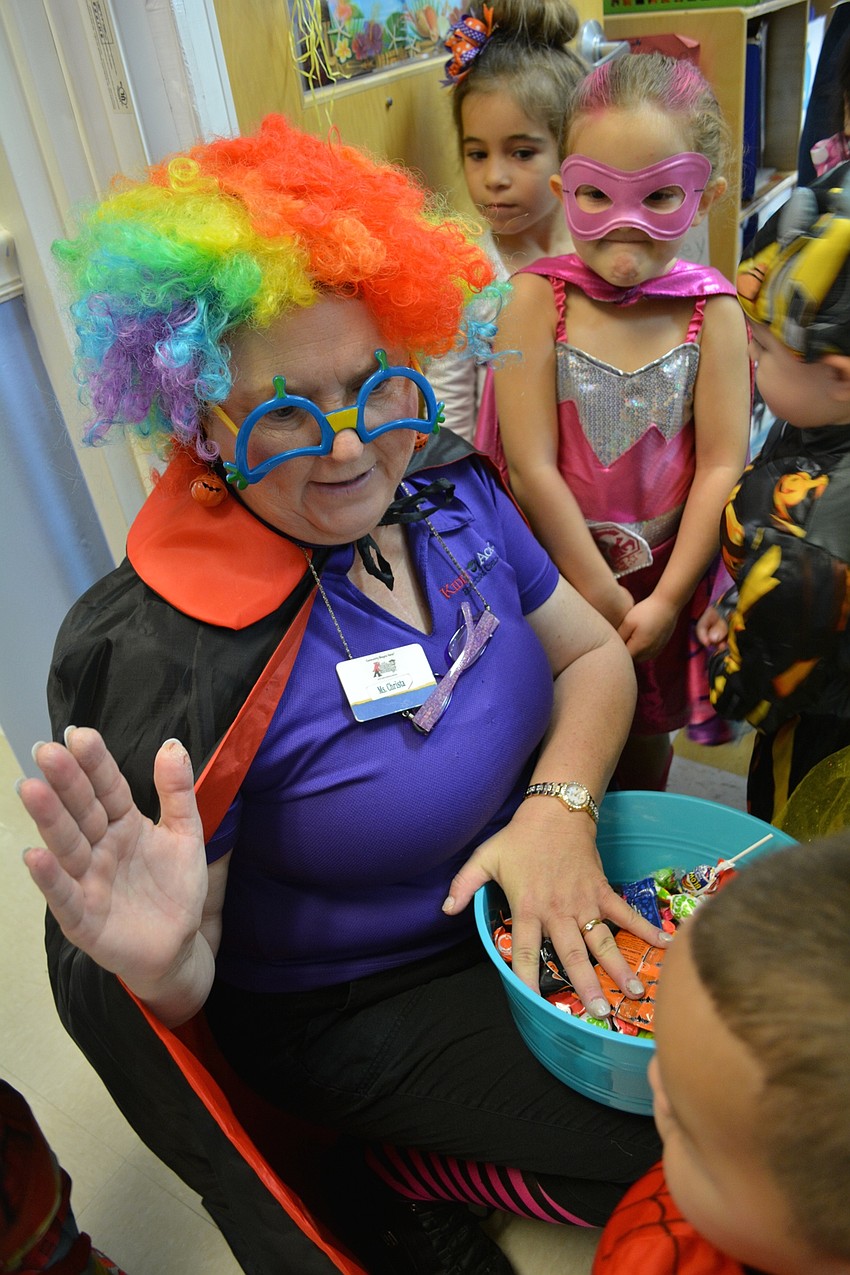 Teacher Christa Breiner gives out candy to parading students as her own students watch.