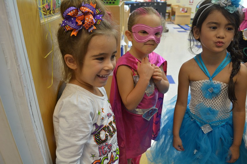 Ourania Gavrilis, left, and Ansley Kidd, center, have fun swatting at the clown hair worn by their teacher, Christa Breiner.