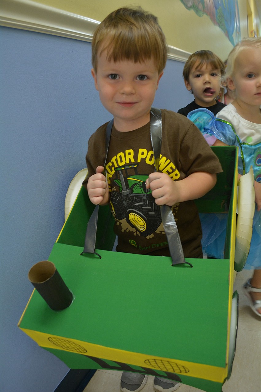 Sullivan Ford, 2, walks in his homemade John Deere tractor costume.