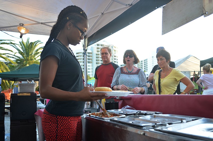 Jessica McKinney of serves costumers at the J&J Barbecue tent. Local vendors sold food throughout the event.