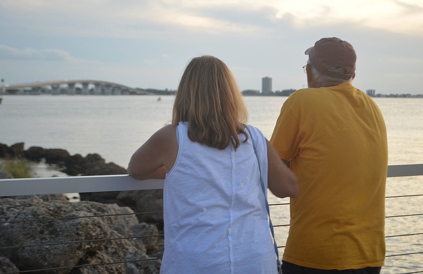 Mona Poyta and Steve Poyta enjoy the view of Ringling Bridge from the grounds of Van Wezel Performing Arts Hall. The pair used to volunteer at the event and still enjoy the live music.