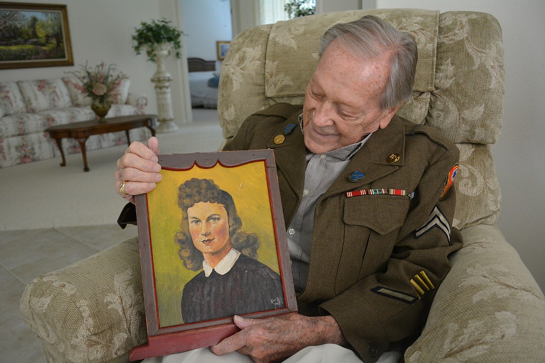 ElRoy York holds a painting of his wife, Agnes. A German prisoner painted it for him from a photograph York kept in his wallet. The artist's name is Kyrih  â€” which York only knows because of the autograph at the bottom of the piece.