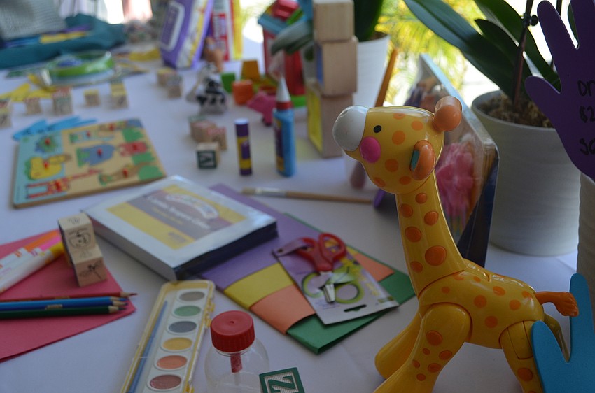 Kids toys, books and art supplies line the auction table.