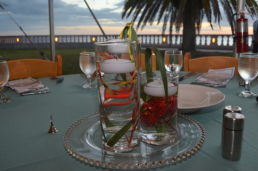 Floral candle centerpieces await guests at each table.