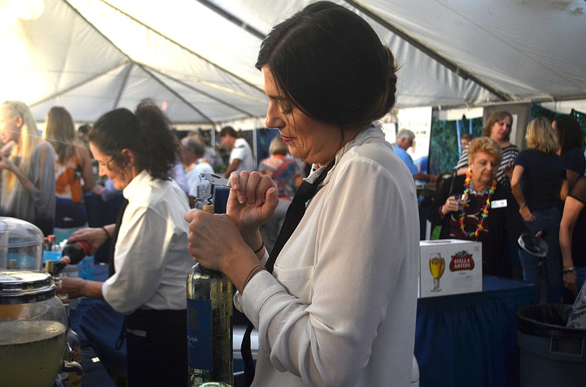 Courtney Reid opens a bottle of wine at the bar.