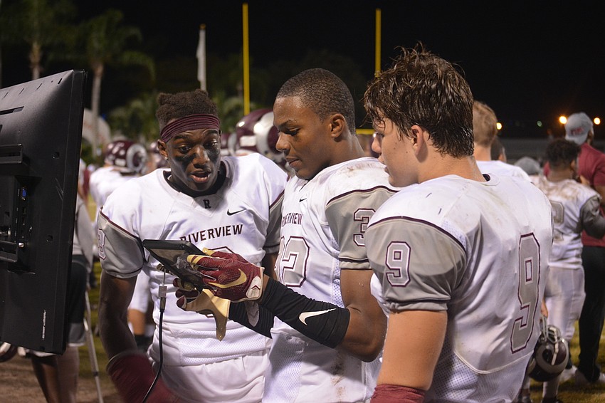 Riverview players Zahodori Jackson, Vince Sellers and Julian Lowenstein watch replays of their game against Sarasota on a tablet computer.
