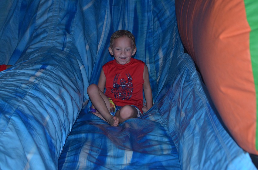 Bradenton's Adam Johnson, 4, has a great time on the inflatable slide.