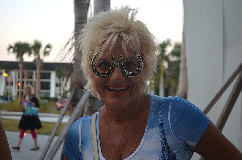 Darina Buettner models a pair of horse shoe glasses outside the photo booth at Sandfest.