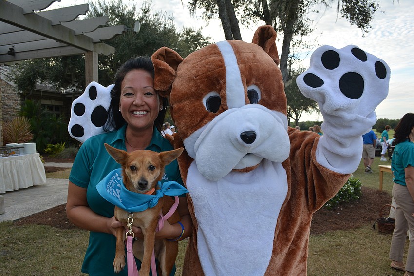 Lakewood Ranch's Rebekah Boos holds 2-year-old Foxy while Ruff the mascot gives both a hug. Christine Legge of Sarasota was Ruff's alter ego.