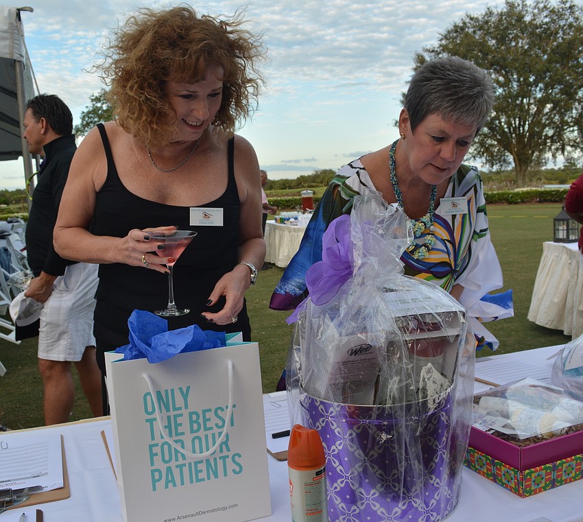Linda Dirk, a volunteer at the Humane Society at Lakewood Ranch, and board member Sandra Simpson look over silent auction items.