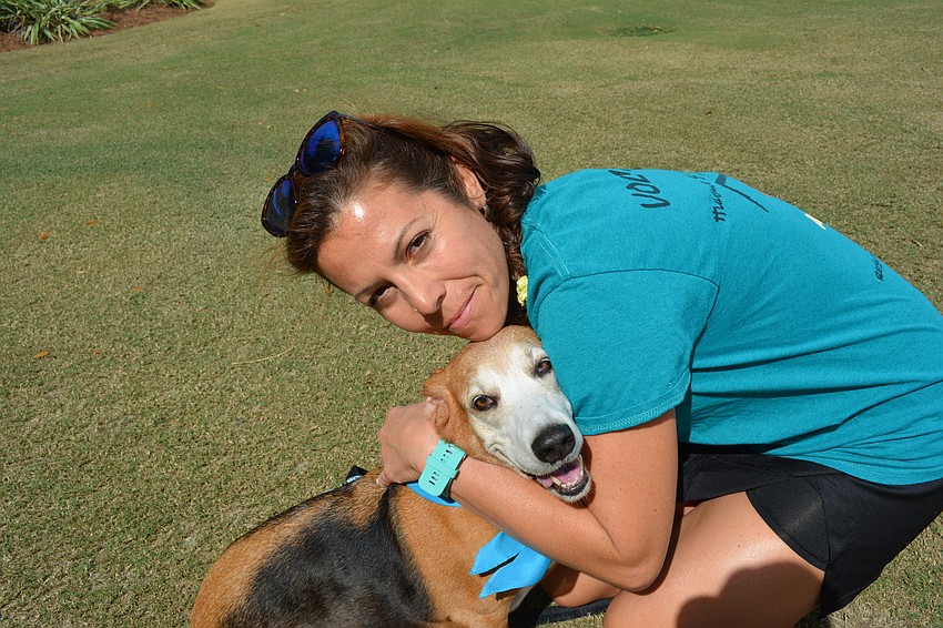 Humane Society volunteer Andrea Rutsky gives Maddie, a 4-year-old Basset Hound, a big hug.