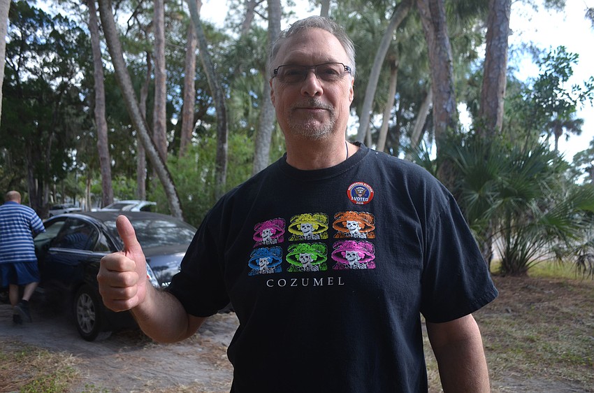 Craig Pollman shows off his sticker outside Siesta Key Chapel on Siesta Key.