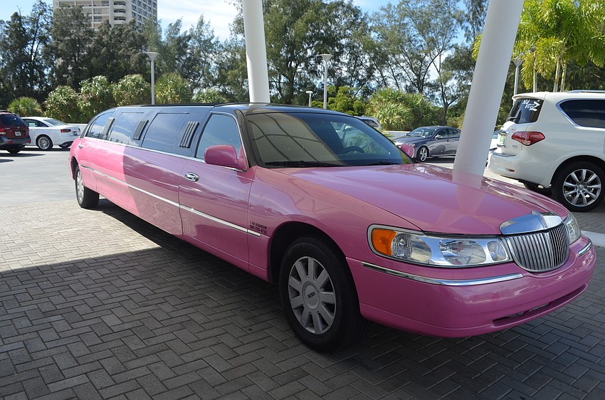 A pink limo sits in park outside the entrance to the Sarasota Yacht Club.