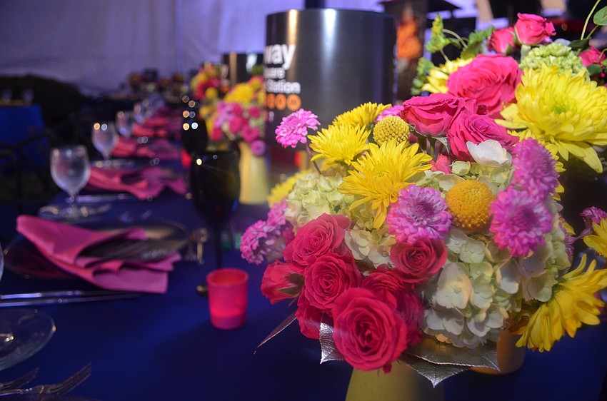 Table settings followed a pink and yellow color scheme with “Guys and Dolls”-inspired touches, such as dice and subway sign lampshades.