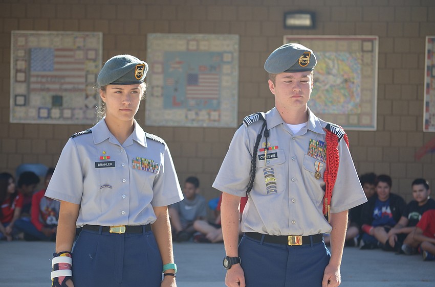 Lakewood Ranch High JROTC members Kendyl Brahler, a sophomore, and Wyatt Christie, a senior, stand at attention as the flag is raised.