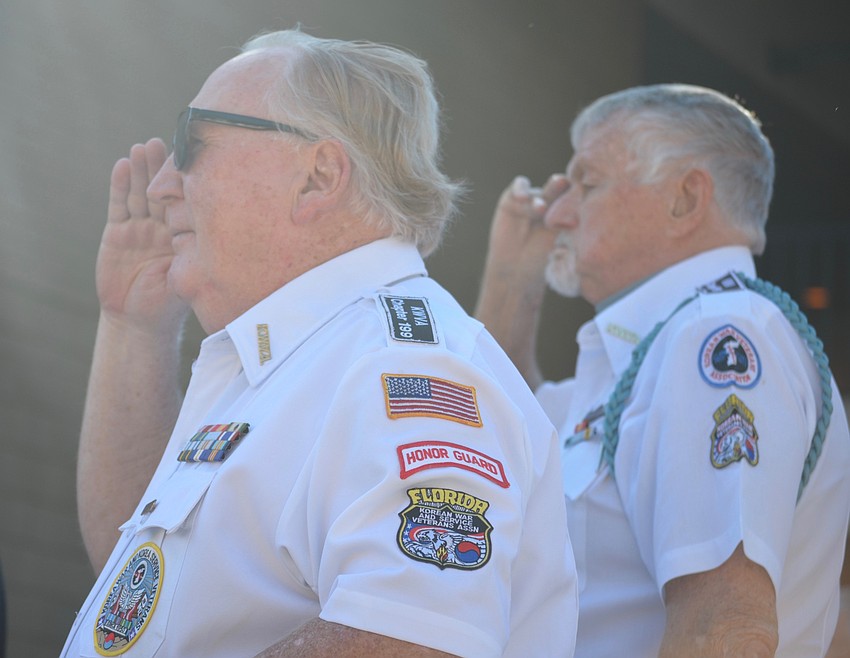 Bill Skinner, commander of the Korean War Veterans, Manasota Chapter 199, and combat veteran Roy Robinson salute during the Veterans Day service.