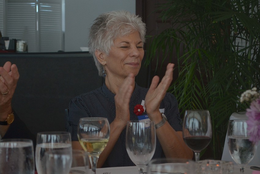 Alaine Thomas claps after event organizer Tom Smith wished the Corps a happy 241st birthday. Thomas, the only female Marine in attendance, quietly added 