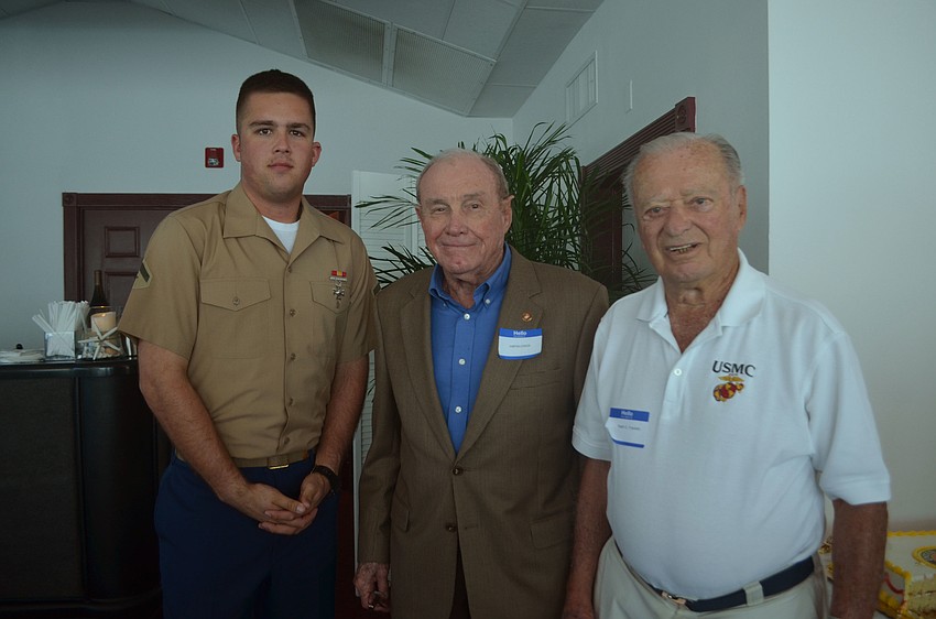 General Jarvis Lynch (middle) cut the Marine Corps cake. The second piece of cake was given World War II veteran Captain Ralph Franklin, the oldest Marine in attendance, who passed it to Lance Cpl. Jackson Stroud, the youngest in attendance.