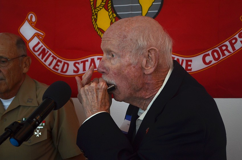 Peter Minotti played taps on a harmonica during a moment of silence to commemorate fallen Marines.