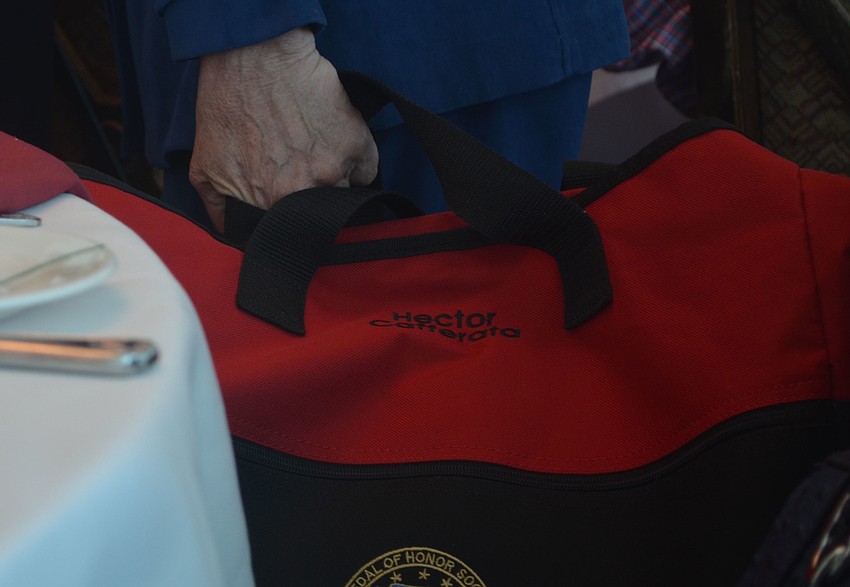 Lynn Cafferata-Coovert carries a bag embroidered with her fathers' name. Her father, Hector Cafferata, was a Korean War veteran and Congressional Medal of Honor recipient.